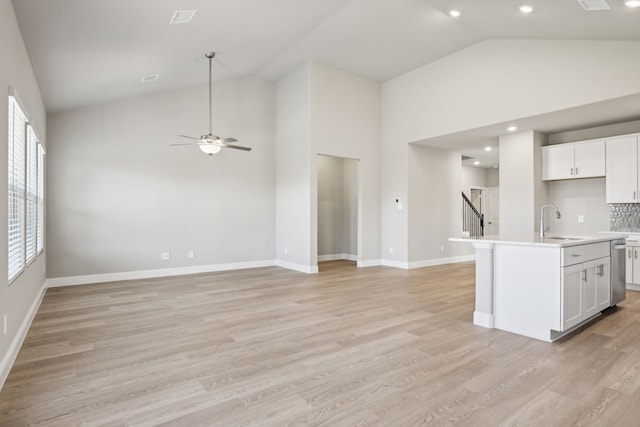 kitchen featuring white cabinetry, sink, light hardwood / wood-style floors, and an island with sink