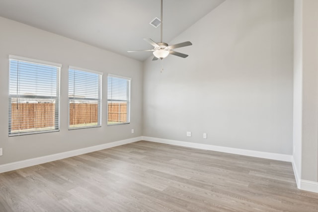 spare room featuring ceiling fan, light wood-type flooring, and lofted ceiling