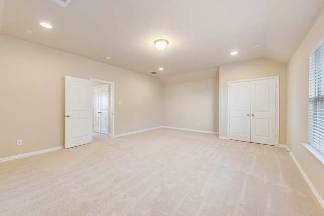 carpeted empty room featuring vaulted ceiling