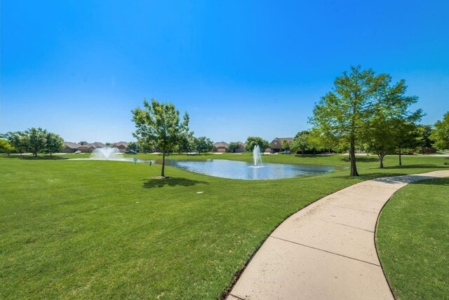 view of home's community with a lawn and a water view