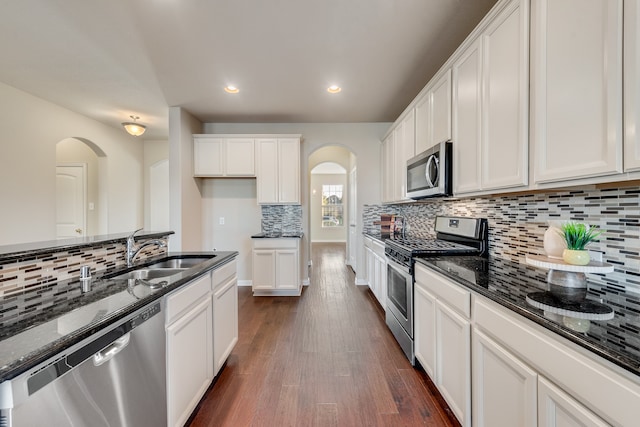 kitchen featuring white cabinets, sink, appliances with stainless steel finishes, and dark stone counters