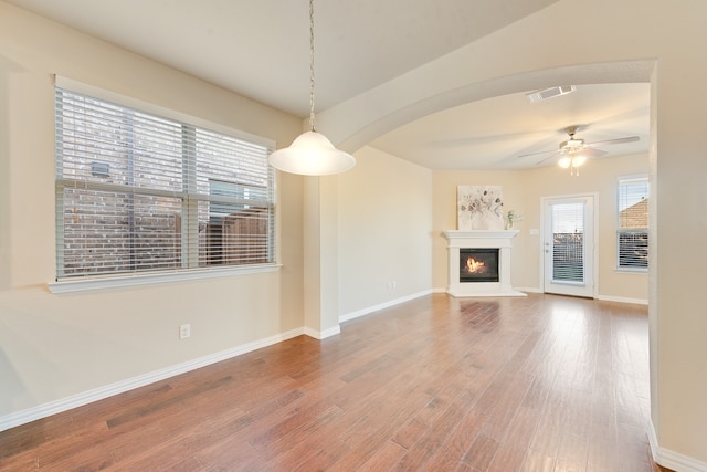 unfurnished living room featuring wood-type flooring and ceiling fan