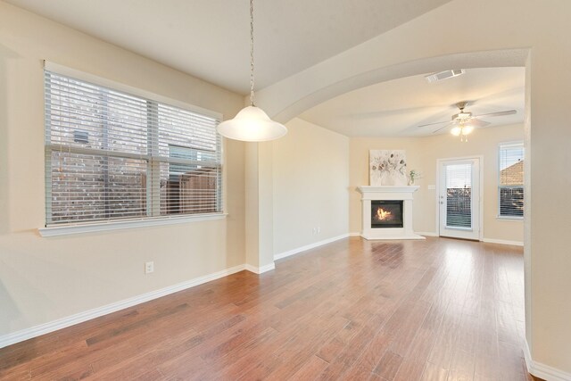 unfurnished living room featuring wood-type flooring and ceiling fan