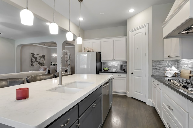 kitchen featuring white cabinets, stainless steel appliances, and a kitchen island with sink