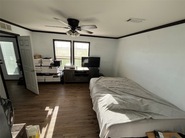 bedroom with ceiling fan, ornamental molding, and dark wood-type flooring