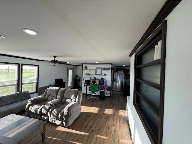 living room featuring ceiling fan, dark hardwood / wood-style flooring, and ornamental molding