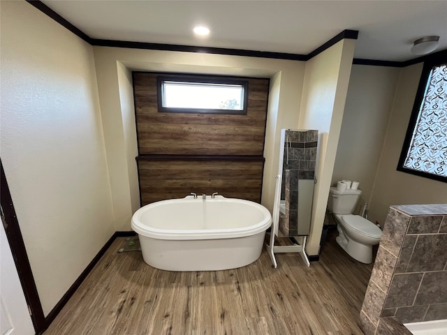 bathroom with a bathing tub, crown molding, toilet, and hardwood / wood-style flooring