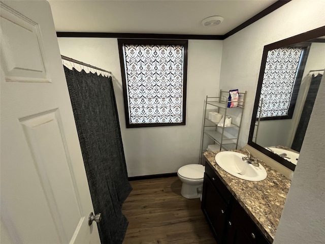 bathroom featuring a shower with curtain, hardwood / wood-style floors, toilet, vanity, and ornamental molding