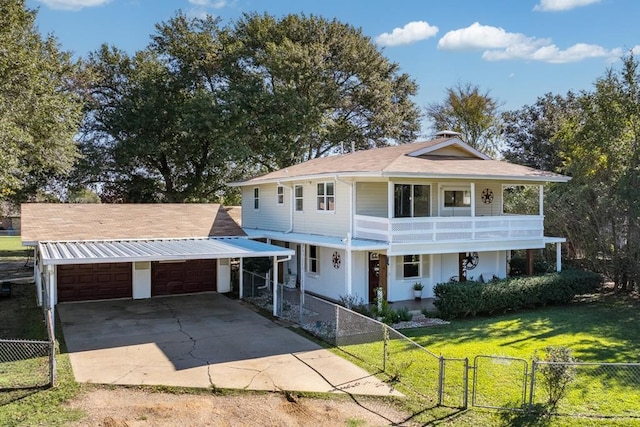 view of front of property with a porch, a balcony, a front yard, and a garage