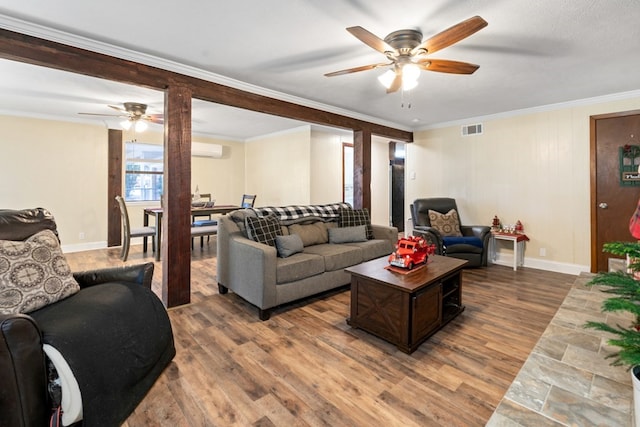 living room featuring ceiling fan, wood-type flooring, crown molding, and a wall mounted AC