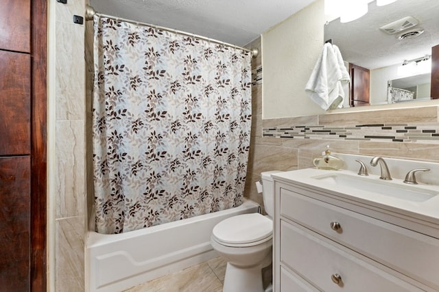 full bathroom with shower / bath combo, vanity, a textured ceiling, tile patterned flooring, and toilet