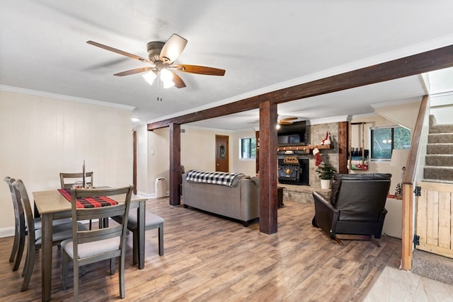 dining space featuring ceiling fan, wooden walls, ornamental molding, and hardwood / wood-style flooring