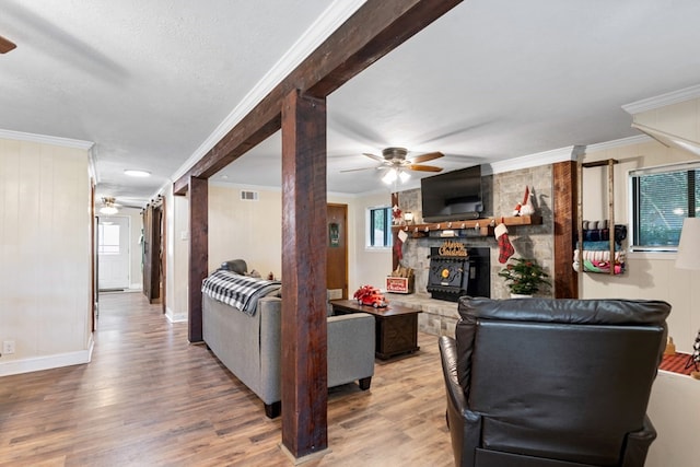 living room with hardwood / wood-style floors, ornamental molding, and a wood stove