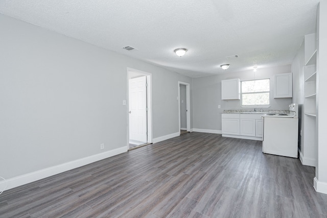 kitchen featuring electric range, white cabinets, dark wood-type flooring, and a textured ceiling