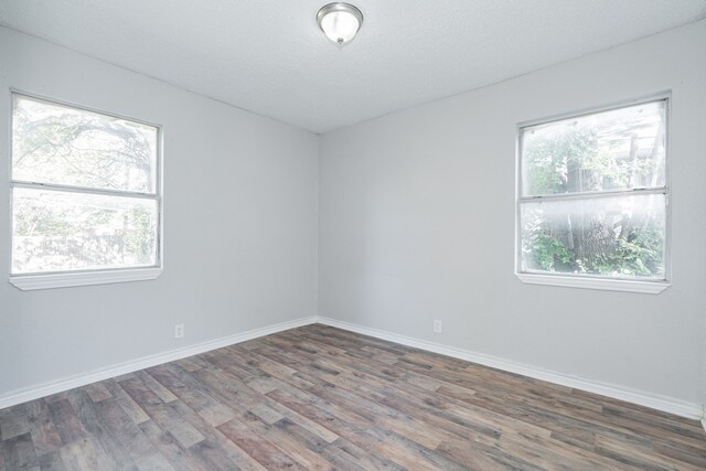 empty room with dark hardwood / wood-style flooring