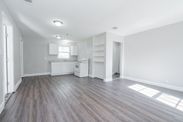 unfurnished living room with hardwood / wood-style floors, a textured ceiling, and sink