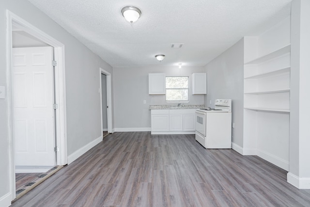 kitchen featuring white cabinets, a textured ceiling, light wood-type flooring, and white electric stove