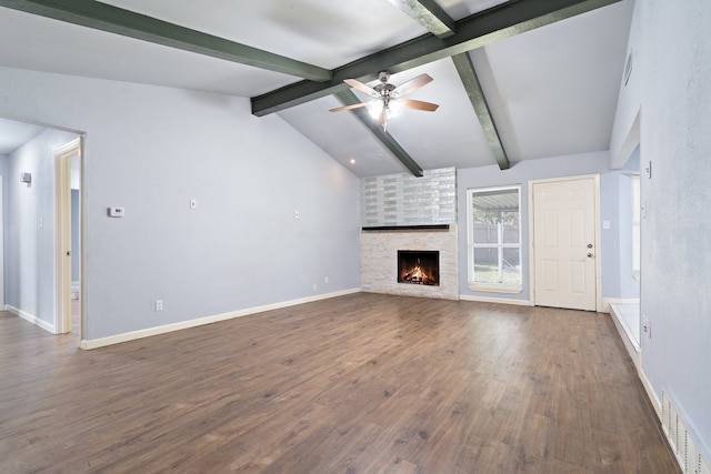 unfurnished living room with a fireplace, lofted ceiling with beams, ceiling fan, and dark wood-type flooring