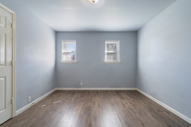 spare room featuring plenty of natural light and dark hardwood / wood-style flooring