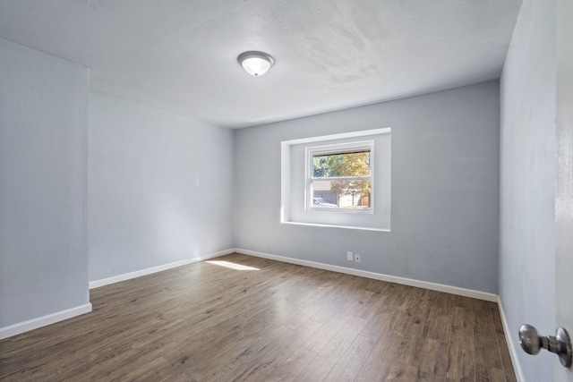 unfurnished room with dark hardwood / wood-style flooring