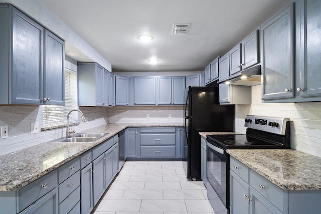 kitchen featuring light stone countertops, sink, stainless steel appliances, backsplash, and light tile patterned flooring