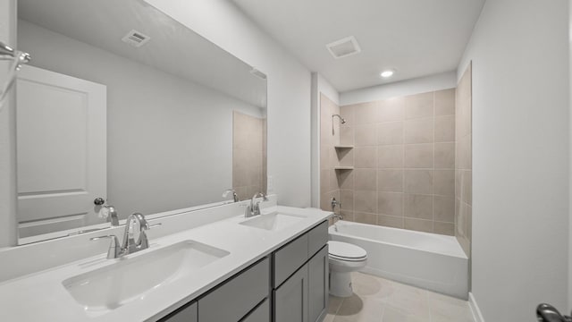 full bathroom with tiled shower / bath combo, vanity, tile patterned floors, and toilet