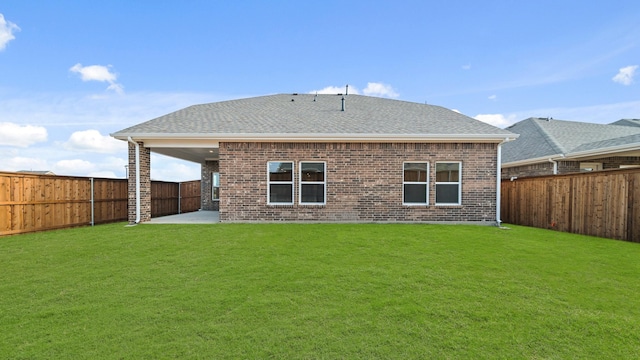 back of house with a patio and a lawn