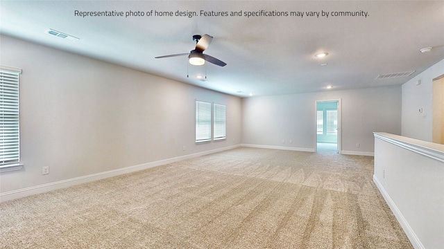 carpeted spare room featuring ceiling fan