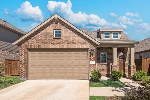 1321 Shire Dr, Aubrey, TX 76227 - view of front facade with fence, concrete driveway, an attached garage, covered porch, and brick siding