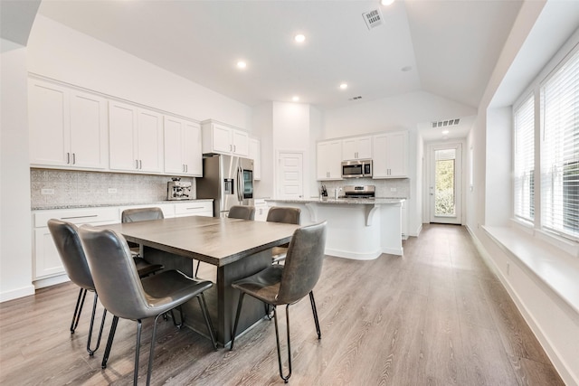 1321 Shire Dr, Aubrey, TX 76227 - dining area with light wood finished floors, vaulted ceiling, visible vents, and recessed lighting