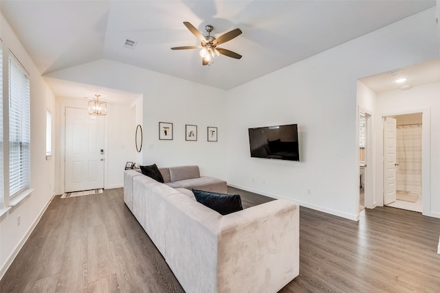 1321 Shire Dr, Aubrey, TX 76227 - living area with vaulted ceiling, wood finished floors, visible vents, and ceiling fan with notable chandelier