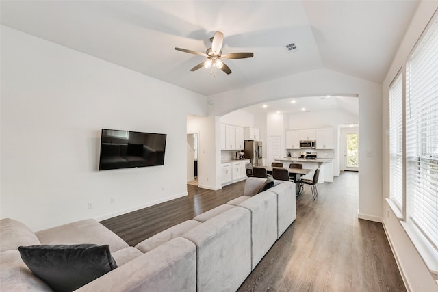1321 Shire Dr, Aubrey, TX 76227 - living area with dark wood-style floors, vaulted ceiling, ceiling fan, arched walkways, and visible vents