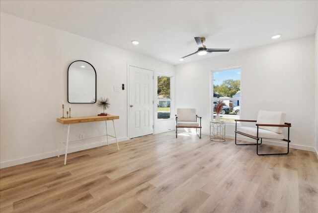 living area featuring ceiling fan and light hardwood / wood-style flooring