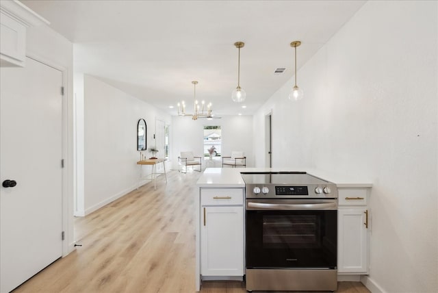 kitchen featuring white cabinetry, light hardwood / wood-style floors, stainless steel range with electric stovetop, and a notable chandelier