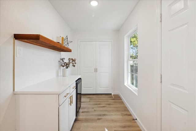 interior space with dishwasher, white cabinetry, and light hardwood / wood-style flooring