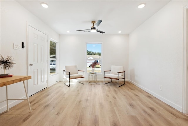 living area with ceiling fan and light hardwood / wood-style floors