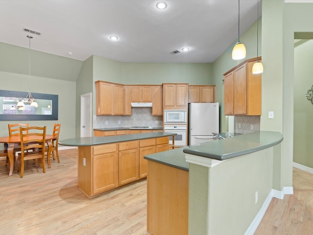 kitchen featuring decorative backsplash, white appliances, light hardwood / wood-style floors, and hanging light fixtures