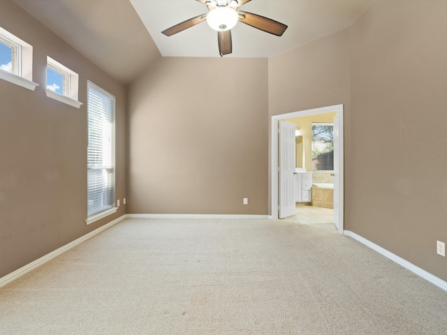 carpeted empty room with ceiling fan and vaulted ceiling