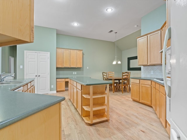 kitchen with a center island, light brown cabinets, white refrigerator, sink, and light wood-type flooring