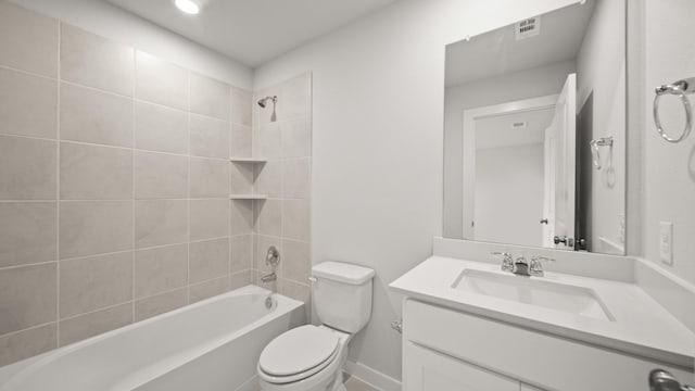 full bathroom with tiled shower / bath, vanity, and toilet