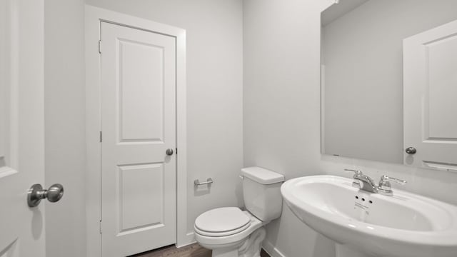 bathroom featuring sink, hardwood / wood-style floors, and toilet