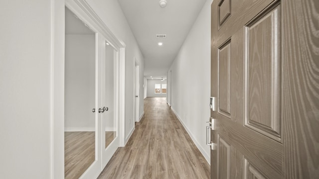 corridor with light hardwood / wood-style floors