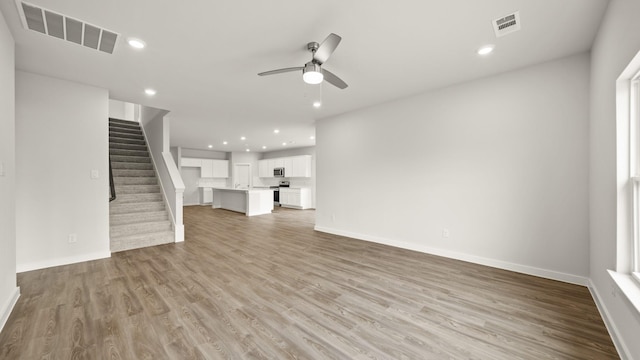 unfurnished living room featuring ceiling fan and light hardwood / wood-style floors