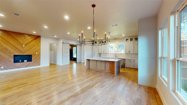 kitchen with a healthy amount of sunlight, light hardwood / wood-style flooring, and a large island