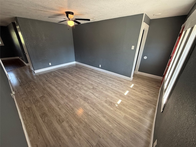 interior space featuring ceiling fan, hardwood / wood-style floors, and a textured ceiling