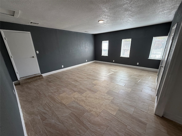 unfurnished room featuring a textured ceiling