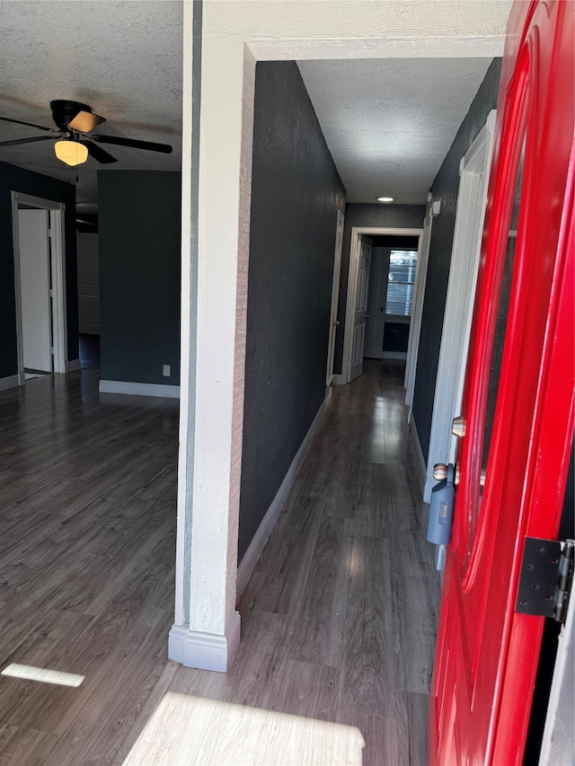 hallway with a textured ceiling and hardwood / wood-style flooring