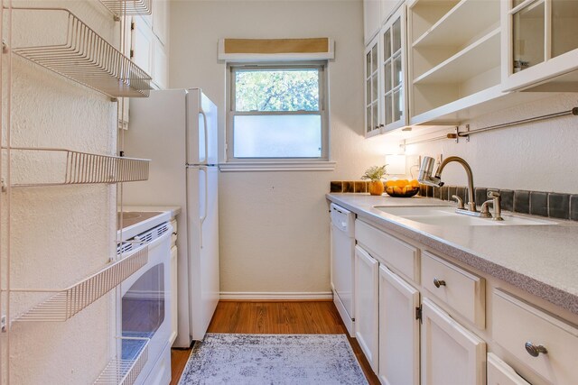 kitchen with white cabinetry, sink, white appliances, and light wood-type flooring