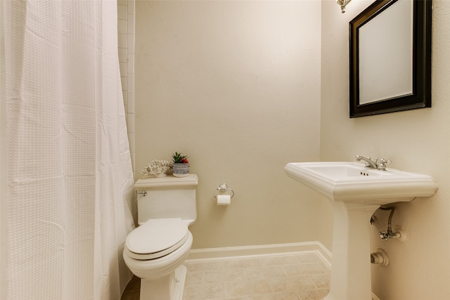 bathroom with curtained shower, tile patterned flooring, and toilet