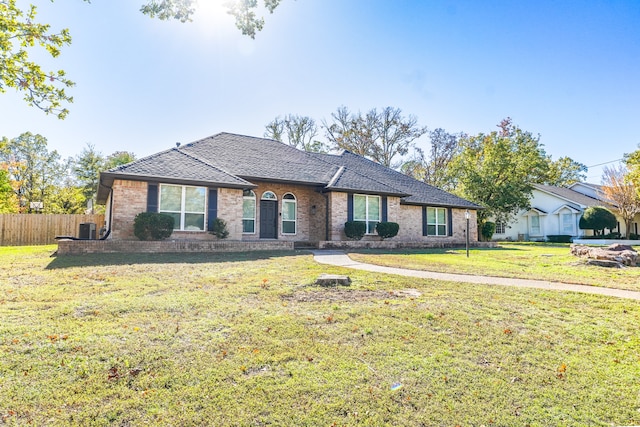 ranch-style home featuring central air condition unit and a front lawn